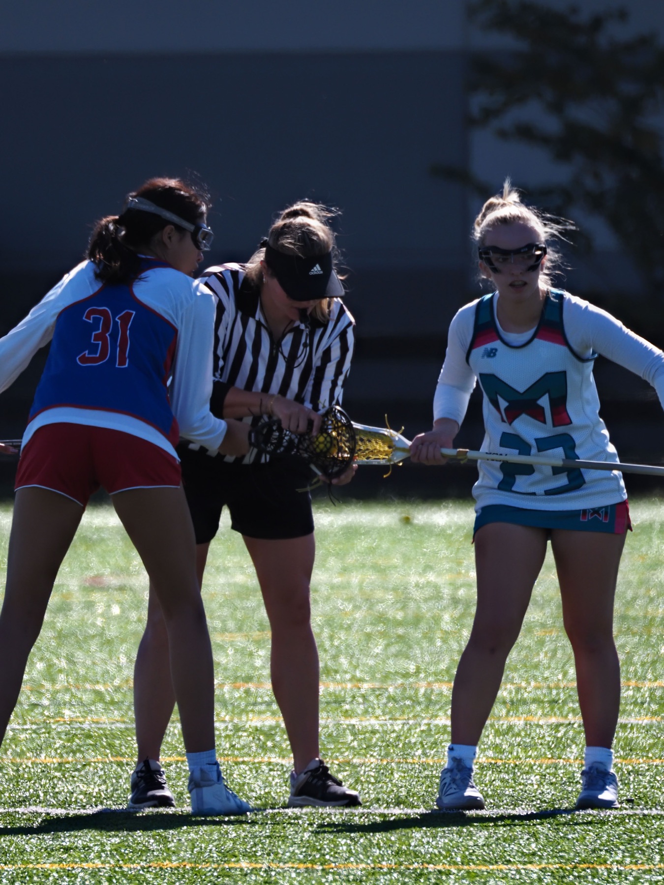 Women lacrosse players lining up for a draw